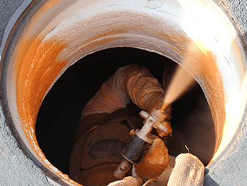 worker spraying and repairing in manhole