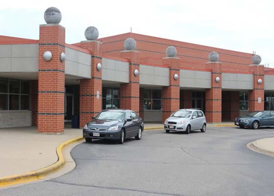 3 cars parked in front of a school building