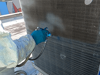 Tech cleaning an HVAC system