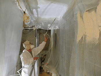 ECM employee applying spray insulation