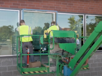 ECM workers on a lift replacing a window