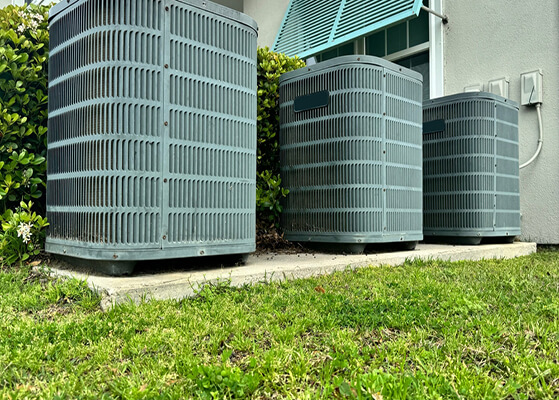 3 outdoor ac air handlers sitting on a concrete pad