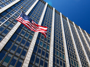 Looking up a skyscraper with an American flag on it